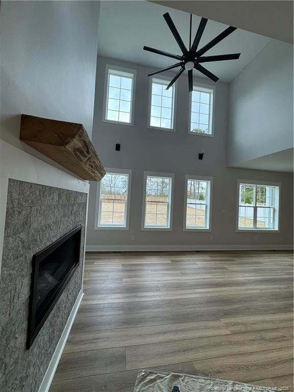 unfurnished living room featuring plenty of natural light, a fireplace, and wood finished floors