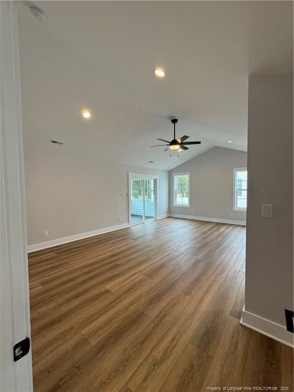 spare room with baseboards, dark wood finished floors, visible vents, ceiling fan, and vaulted ceiling