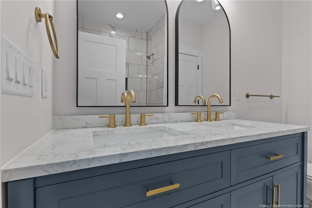 bathroom featuring double vanity, a sink, toilet, and walk in shower