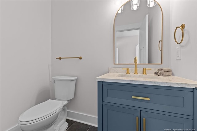 bathroom featuring baseboards, toilet, tile patterned floors, and vanity
