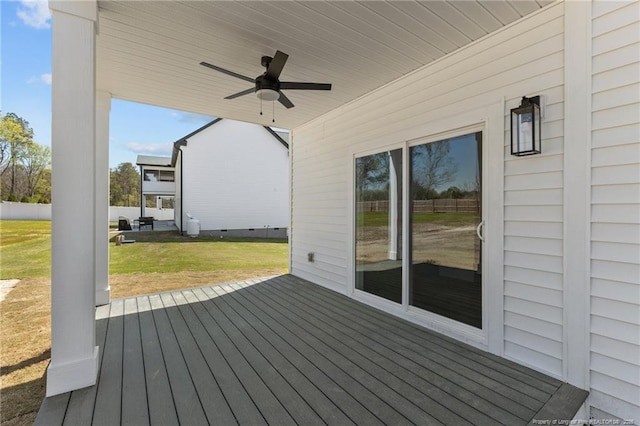 wooden deck with a lawn and ceiling fan