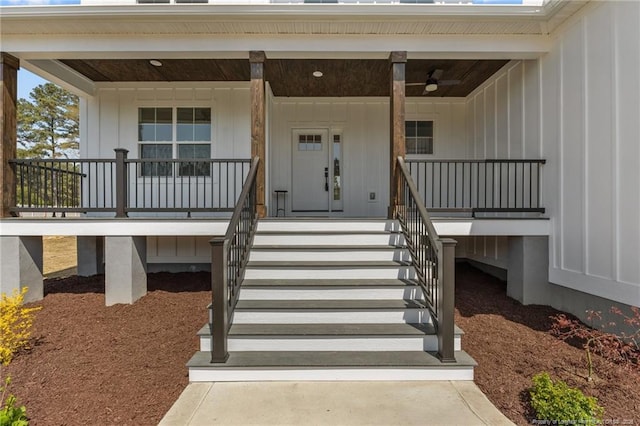 view of exterior entry with board and batten siding and a porch