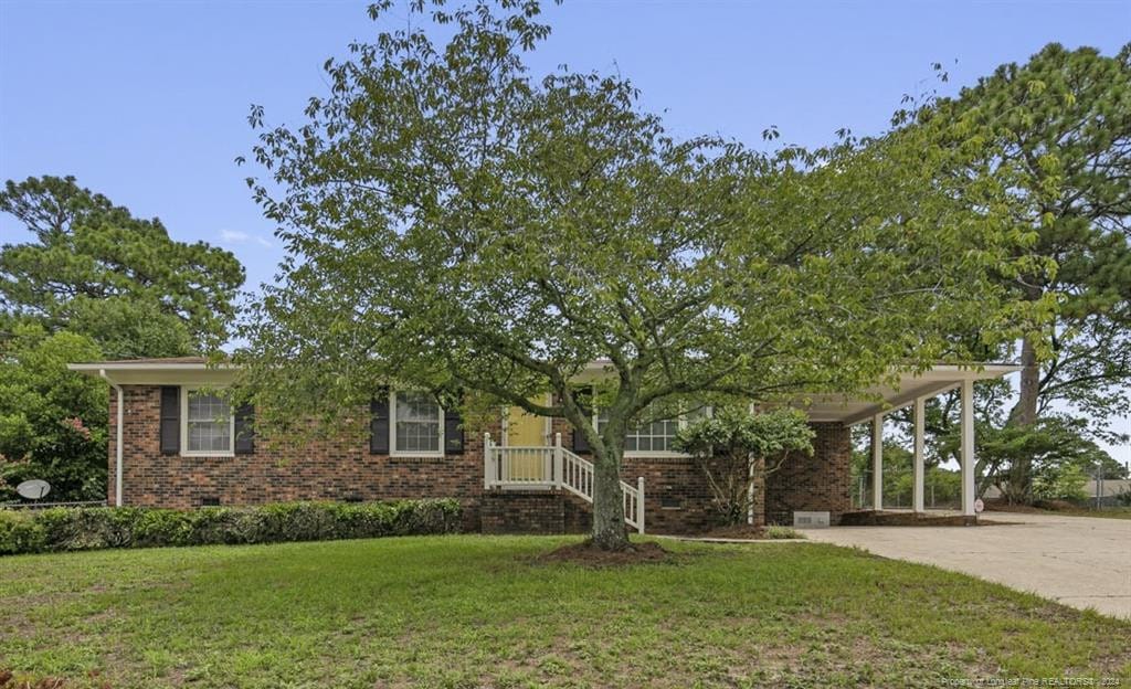 view of front of property featuring a carport and a front yard