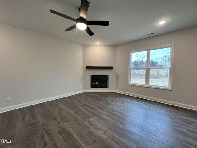 unfurnished living room with dark wood-type flooring and ceiling fan