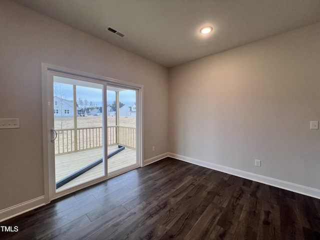 empty room with dark wood-type flooring and a water view