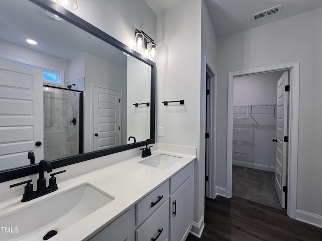 bathroom featuring vanity, wood-type flooring, and walk in shower