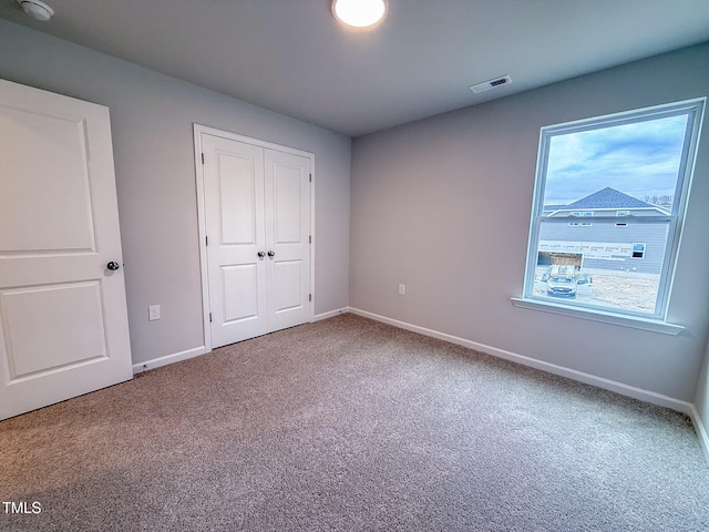 unfurnished bedroom featuring carpet floors and a closet