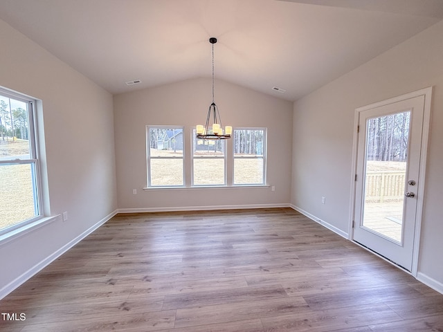 unfurnished dining area featuring lofted ceiling, a notable chandelier, and light wood-type flooring