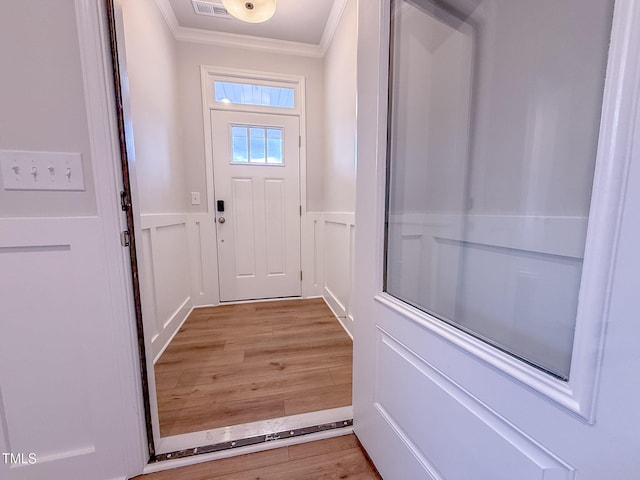 entryway featuring crown molding and light hardwood / wood-style flooring