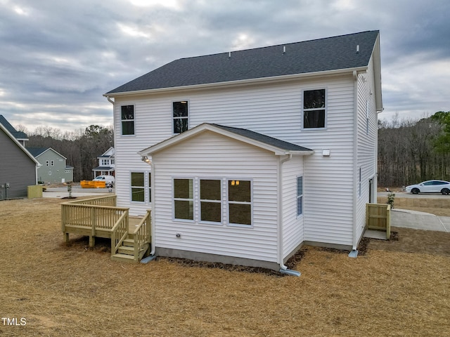 back of property with a yard and a deck