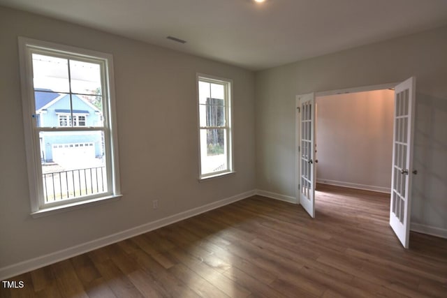 spare room featuring dark hardwood / wood-style floors and french doors