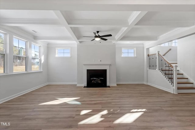 unfurnished living room featuring coffered ceiling, hardwood / wood-style floors, and beamed ceiling