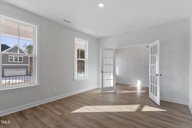 unfurnished room with hardwood / wood-style flooring and french doors