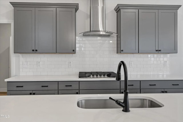 kitchen with gray cabinetry and wall chimney range hood