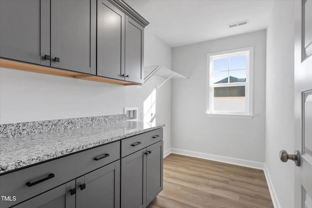 washroom featuring cabinets, washer hookup, and light hardwood / wood-style flooring