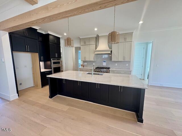 kitchen featuring custom exhaust hood, beamed ceiling, pendant lighting, and a spacious island