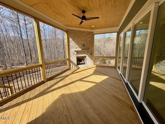 unfurnished sunroom featuring wooden ceiling and ceiling fan