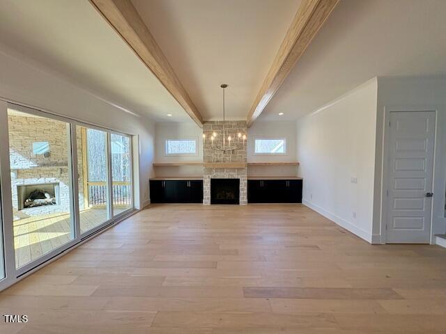 unfurnished living room featuring plenty of natural light, a fireplace, and light wood-type flooring