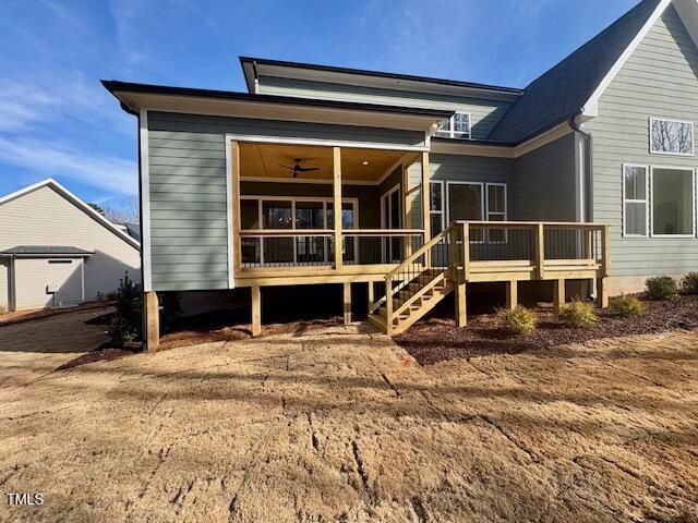 back of house with ceiling fan and a deck