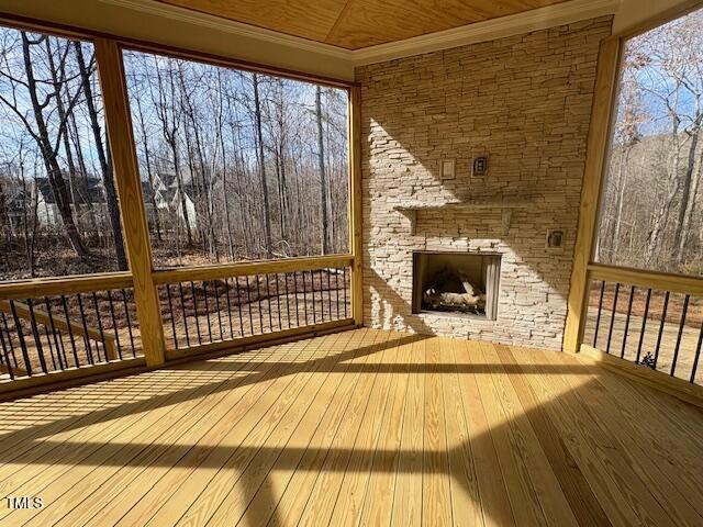 wooden terrace featuring a stone fireplace