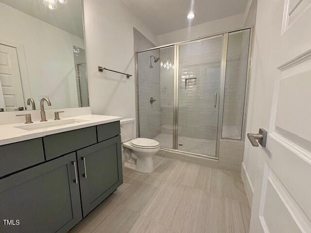 bathroom with vanity, an enclosed shower, and toilet