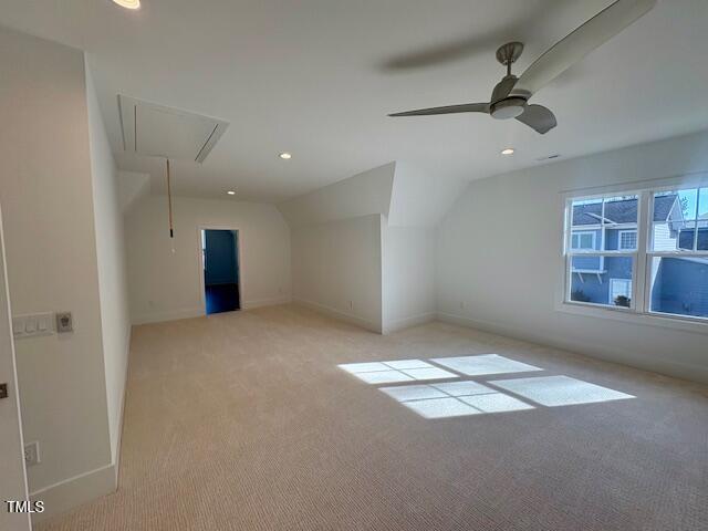 additional living space with lofted ceiling, light colored carpet, and ceiling fan