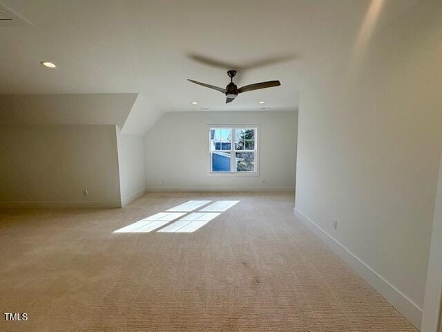 additional living space featuring ceiling fan, light colored carpet, and lofted ceiling