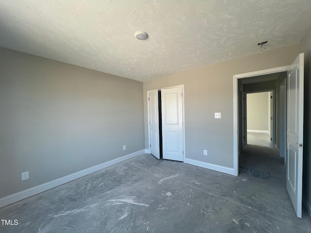 unfurnished bedroom featuring a textured ceiling and a closet