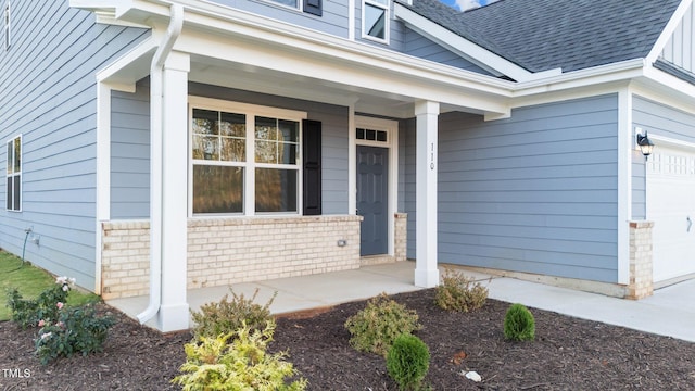 doorway to property featuring a garage and covered porch