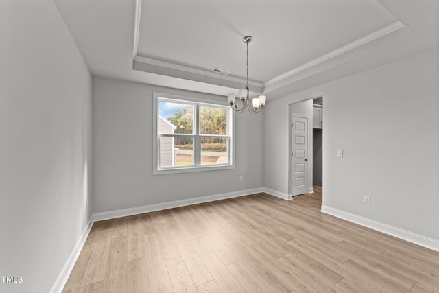 110 Merrifield Ln, Garner, NC 27529 - spare room featuring a tray ceiling, a chandelier, light wood-type flooring, baseboards, and ornamental molding