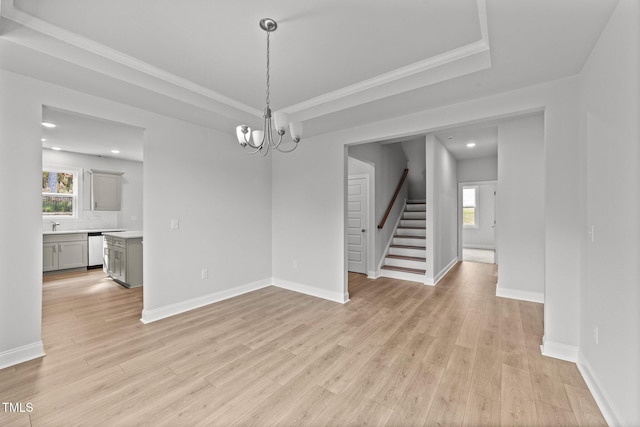 empty room featuring light hardwood / wood-style floors, an inviting chandelier, and ornamental molding