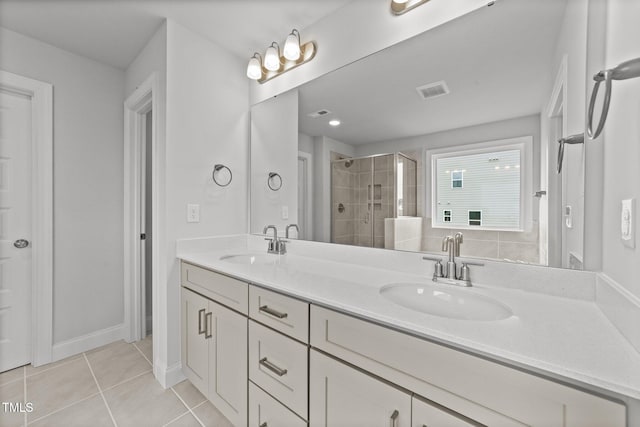 bathroom featuring vanity, a shower with shower door, and tile patterned floors