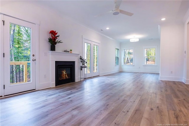 unfurnished living room featuring ceiling fan and light wood-type flooring