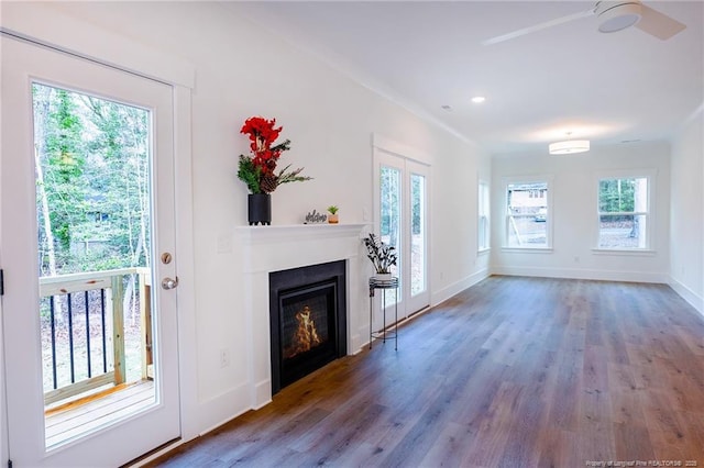 unfurnished living room featuring hardwood / wood-style flooring, ceiling fan, and a wealth of natural light