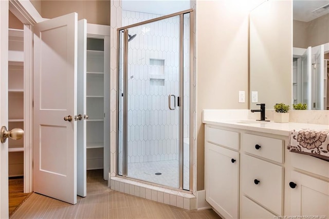 bathroom featuring vanity and a shower with door