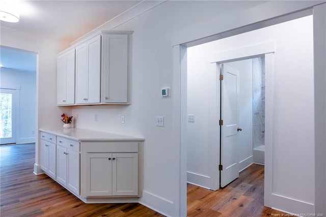 interior space with hardwood / wood-style flooring and white cabinetry