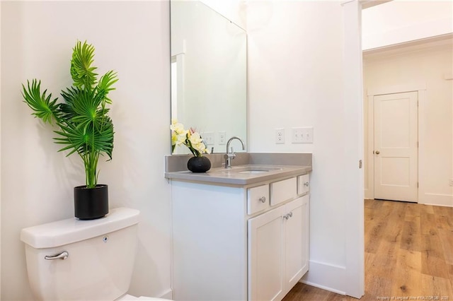 bathroom featuring vanity, wood-type flooring, and toilet