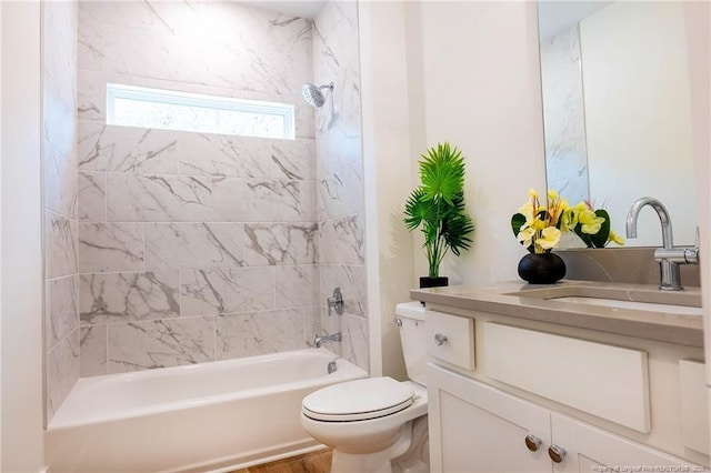 full bathroom featuring vanity, tiled shower / bath combo, and toilet