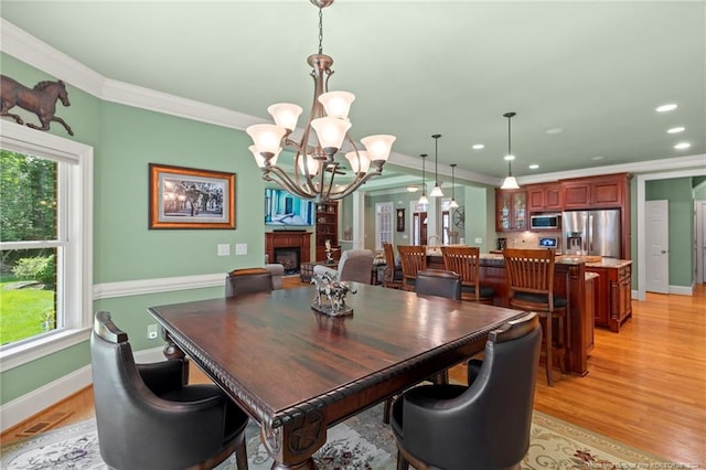 dining room with crown molding, baseboards, recessed lighting, light wood-style flooring, and a notable chandelier