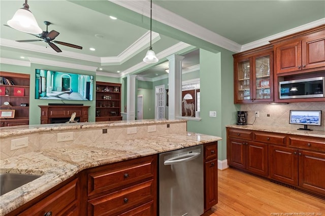 kitchen with stainless steel appliances, open floor plan, ceiling fan, and light stone countertops