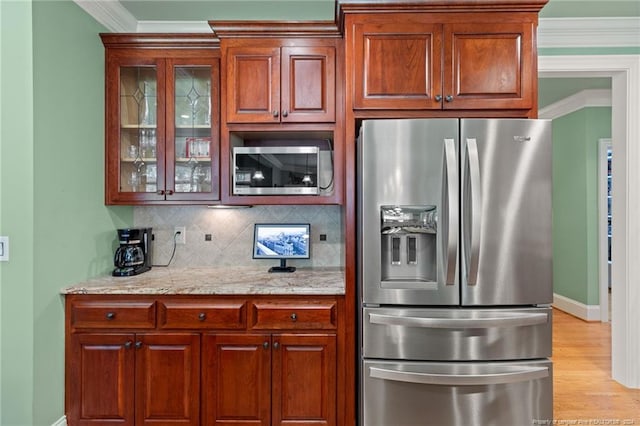 kitchen featuring tasteful backsplash, appliances with stainless steel finishes, glass insert cabinets, and ornamental molding