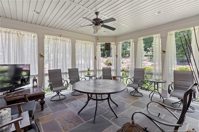 sunroom with stone tile floors and wooden ceiling