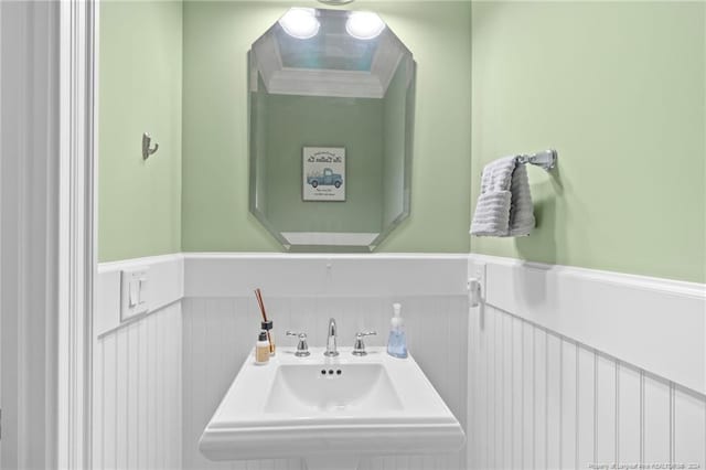 bathroom featuring a wainscoted wall and a sink