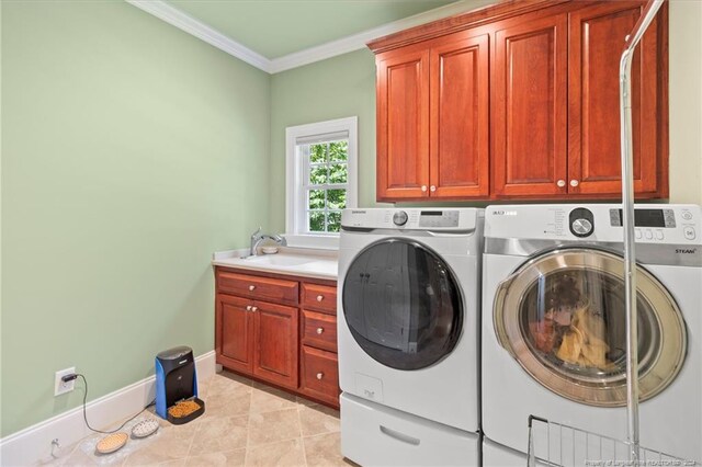 washroom featuring a sink, cabinet space, crown molding, and washing machine and clothes dryer