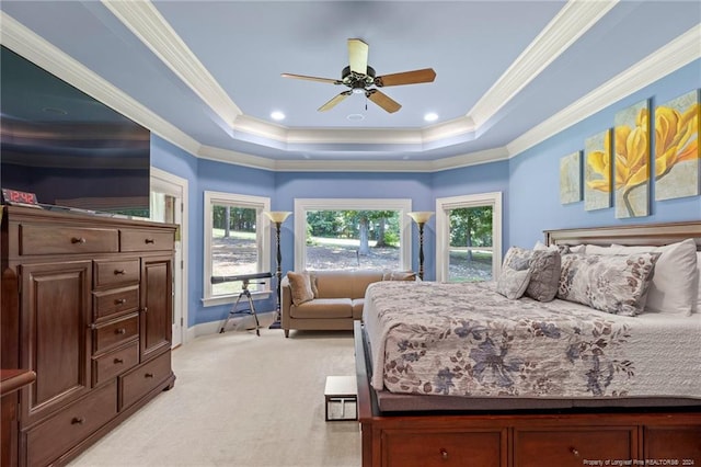 bedroom with light colored carpet, a tray ceiling, and ornamental molding