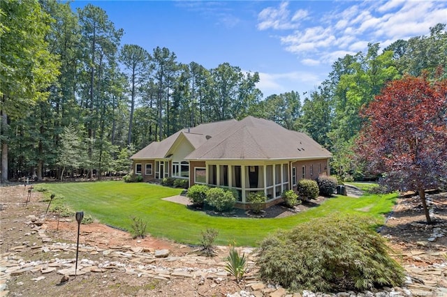 back of property featuring a yard and a sunroom