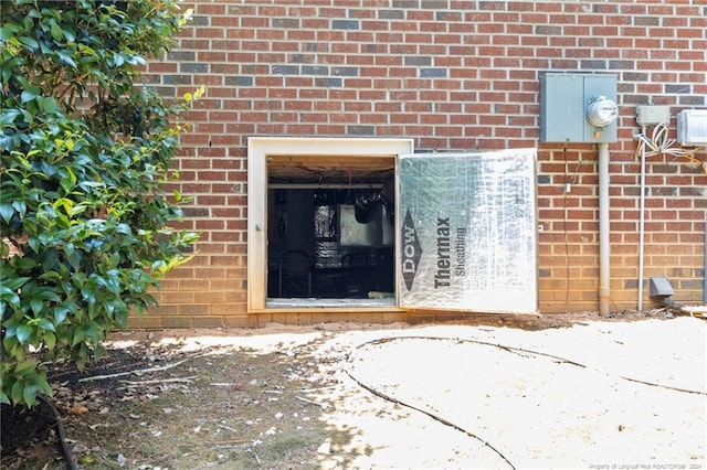 view of exterior entry featuring brick siding