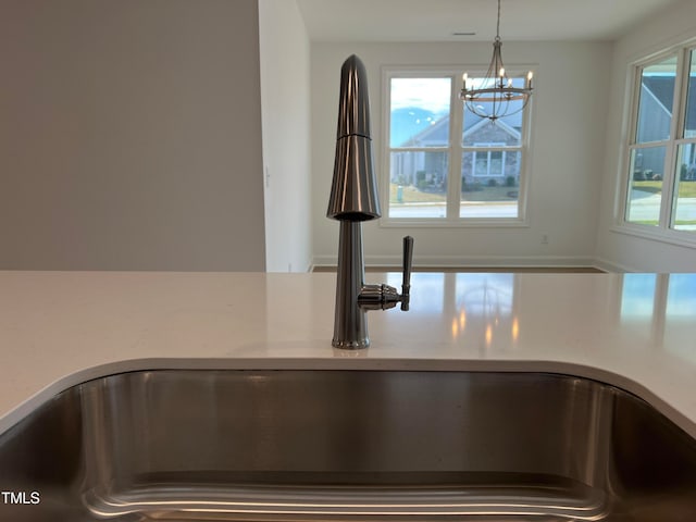 details with pendant lighting, sink, and an inviting chandelier