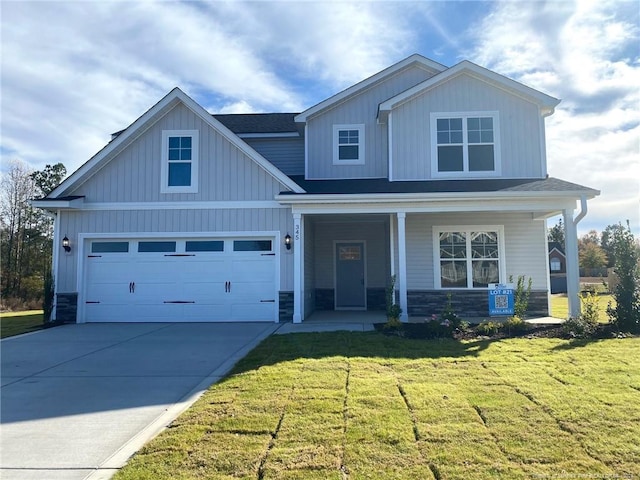 view of front of home with a porch, a front yard, and a garage