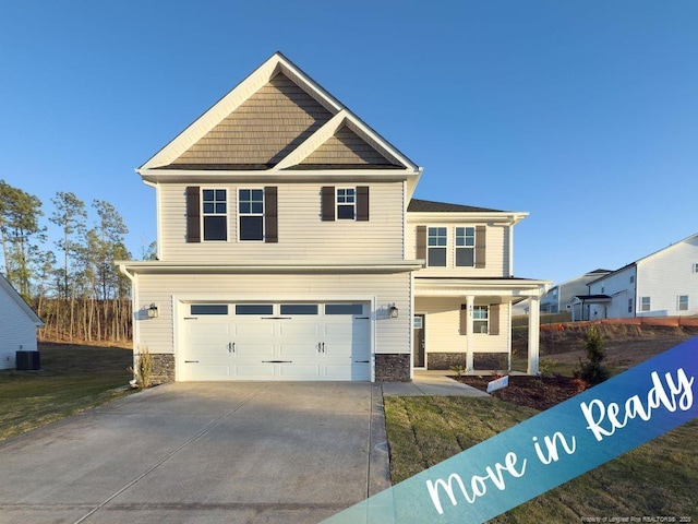 view of front of property featuring central air condition unit, stone siding, an attached garage, and driveway